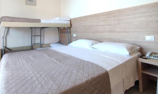 Room with double bed and bunk bed, simple and bright.